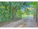 Gravel driveway lined with trees leading to a gated entrance at 1565 Dr Bramblett Rd, Cumming, GA 30028