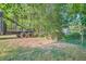 Gravel driveway and metal gate leading to a wooded area at 1565 Dr Bramblett Rd, Cumming, GA 30028