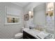 Stylish bathroom with patterned wallpaper, marble vanity, and gold fixtures at 3250 Arborwoods Dr, Alpharetta, GA 30022