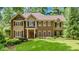 Brick and shingle two-story home with landscaped lawn and mature trees at 3250 Arborwoods Dr, Alpharetta, GA 30022