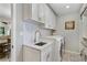 Bright laundry room with custom cabinets and hexagon tile flooring at 3250 Arborwoods Dr, Alpharetta, GA 30022