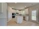 Bright kitchen boasts white cabinets, stainless steel appliances, and an island at 565 Teversham Dr, Mcdonough, GA 30253