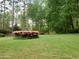 Spacious backyard with lush green grass, trees, and blooming pink azaleas surrounding a fountain at 3368 Ashford Dunwoody Rd, Atlanta, GA 30319