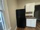 Black refrigerator in a kitchen with white cabinets at 603 Willard Sw Ave, Atlanta, GA 30310