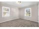 Spacious bedroom with neutral walls, plush carpeting, and two windows at 2415 Plantation Dr, Atlanta, GA 30344