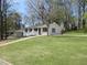 White ranch house with a spacious lawn and mature trees at 6325 Westbury Rd, Riverdale, GA 30274