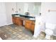 Double vanity bathroom with wood cabinets and a separate toilet area at 6298 Hampstead Ln, Douglasville, GA 30134