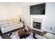 Spacious living room with fireplace, hardwood floors, and large TV at 6298 Hampstead Ln, Douglasville, GA 30134