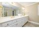 Spacious bathroom featuring white vanity with gold fixtures, large mirror, and tiled floor at 1841 Kanawha Trl, Smoke Rise, GA 30087