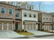 Townhouse with brick and white exterior, 2-car garage, and landscaping at 1592 Wellborn Walk, Suwanee, GA 30024