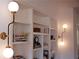 Built-in shelving with books and decorative objects, illuminated by stylish wall sconces at 3443 Landen Pine Ne Ct, Atlanta, GA 30305