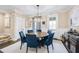 Formal dining room featuring a round wooden table and blue upholstered chairs at 217 Bluestone Dr, Woodstock, GA 30188