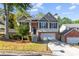 Two-story house with brick and siding exterior, attached garage, and landscaped yard at 2140 Wildcat Cliffs Way, Lawrenceville, GA 30043