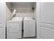 White washer and dryer set in a well-lit laundry room at 2140 Wildcat Cliffs Way, Lawrenceville, GA 30043