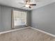 Cozy bedroom with neutral walls, plush carpet, and a large window at 790 Eskew Rd, Mcdonough, GA 30252