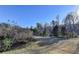 Landscaped backyard with a sloped yard and trees at 5732 Cypress Bluff Ln, Hoschton, GA 30548