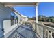 Covered deck with wooden railings, offering scenic views at 5732 Cypress Bluff Ln, Hoschton, GA 30548