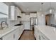 Modern kitchen with white cabinets, island, and stainless steel appliances at 5732 Cypress Bluff Ln, Hoschton, GA 30548