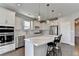 Modern kitchen with white cabinets, island, and stainless steel appliances at 5732 Cypress Bluff Ln, Hoschton, GA 30548