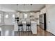 Modern kitchen with white cabinets, island, and stainless steel appliances at 5732 Cypress Bluff Ln, Hoschton, GA 30548
