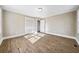 Well-lit bedroom with neutral walls, wood-look floors, and two windows at 996 Marietta Rd, Canton, GA 30114