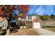 Two-story house with brick and vinyl siding, a driveway, and a tree with autumn leaves at 6930 Red Bone Way, Lithonia, GA 30038