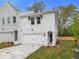 Two-story townhome with white and gray siding, two-car garage, and landscaped yard at 699 Sunstone Ln, Lawrenceville, GA 30043