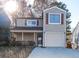 Tan two-story house with a garage and small front porch at 1184 Red Oak Cv, Tucker, GA 30084