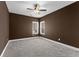 Spacious bedroom with brown walls, gray carpet, and two windows at 201 Mcgarity Rd, Temple, GA 30179