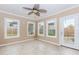 Bright sunroom with tile flooring, ceiling fan, multiple windows, and access to the backyard at 4159 Berwick Farm Dr, Duluth, GA 30096