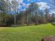 Open green space with mature trees behind the property line at 2484 Honey Way, Conyers, GA 30013