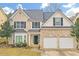 Two-story house with brick and vinyl siding, two-car garage, and landscaping at 840 Minor Creek Nw Way, Lilburn, GA 30047