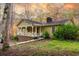 House exterior showcasing a large front porch and brick foundation, surrounded by lush greenery at 1175 Huey Rd, Douglasville, GA 30134