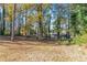 Overgrown backyard with mature trees and a view of neighboring houses at 8775 Lee Rd, Lithia Springs, GA 30122
