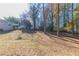 Wooded backyard with a sloped terrain and mature trees at 8775 Lee Rd, Lithia Springs, GA 30122