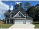 Two story home with gray siding, white trim, and a three car garage at 3066 Zodiac Ct, Lawrenceville, GA 30044