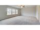 Spacious bedroom featuring carpet, ceiling fan, and multiple windows at 412 Brekston Way, Mcdonough, GA 30253