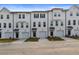 Front view of townhomes with white siding, black accents, and two-car garages at 3218 Bateman Se Dr, Atlanta, GA 30354