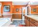 Double vanity bathroom with orange walls and a bathtub at 3120 Avondale Pkwy, Powder Springs, GA 30127