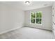 Simple bedroom with grey carpet, a window, and a door at 469 Maypop Ln, Woodstock, GA 30188