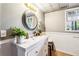 Basement bathroom with white vanity and round mirror at 1445 Sheridan Ne Walk, Atlanta, GA 30324