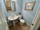 Light blue powder room with pedestal sink and tile floor at 5791 Warren Farm Sw Rd, Powder Springs, GA 30127