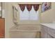 Bathroom featuring a corner jacuzzi bathtub and window with blinds at 1651 Links Overlook, Stone Mountain, GA 30088