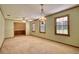 Empty dining room with light green walls, carpet, large windows, and chandelier at 11790 Brown Bridge Rd, Covington, GA 30016