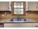 Close-up view of a kitchen sink with granite countertop and window at 11790 Brown Bridge Rd, Covington, GA 30016