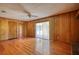 Living area with wood-paneled walls, sliding glass door, and hardwood floors at 11790 Brown Bridge Rd, Covington, GA 30016