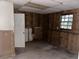 Unfinished basement with wood paneling, a door, and a window, showing signs of water damage at 125 Belmont Farms Dr, Ellenwood, GA 30294