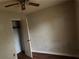 Bedroom featuring wood-look floors, ceiling fan, and an open closet door at 125 Belmont Farms Dr, Ellenwood, GA 30294