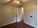 Bedroom with wood-look floors, ceiling fan, and open door to another room at 125 Belmont Farms Dr, Ellenwood, GA 30294