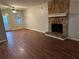 Living room with wood-look floors, stone fireplace, and access to the backyard at 125 Belmont Farms Dr, Ellenwood, GA 30294